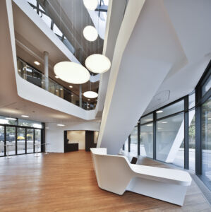 L'interazione tra le forme decise delle lampade e l'ampia apertura dell'atrio crea una particolare atmosfera (©Martin Duckek)