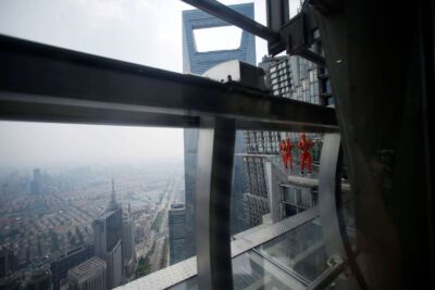 Jin Mao employee walks 340 meters above the ground around the newly opened Jin Mao tower skywalk in Shanghai. (Photo: Reuters)