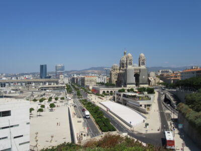 Esplanade La Major, con la cattedrale di Saint-Marie-Majeure (Fortier e Savignat, 2016); al di sotto della spianata è stato realizzato uno spazio commerciale di settemila metri quadrati. Sullo sfondo, La Marseillaise di Nouvel (2018) e la torre Cma Cgm di Hadid (2010)