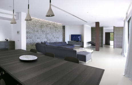 A sinistra, il rivestimento parietale in pietra calcare texturizzata, opera dell’artista Pinuccio Sciola (© Pierluigi Piu)