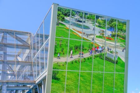 Riflesso del Rike Park sulla vetrata della stazione della funivia (foto Thania Rodrigues da Pixabay)