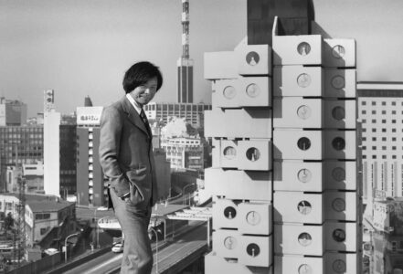 Kishō Kurokawa di fronte alla Nakagin Capsule Tower appena completata, 1974 (© Tomio Ohashi)