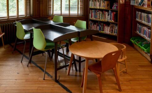 Sala di lettura della Haskell Free Library and Opera House. Una striscia nera attraversa il pavimento e segna il confine tra Stati Uniti e Canada, dividendo ambienti progettati come unità domestiche e civiche continue