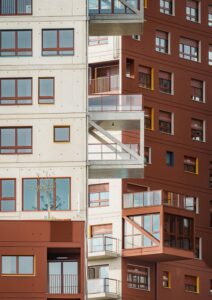 I principali trattamenti di facciata — cemento grezzo e vernice rossa — richiamano la storia architettonica di Ivry, in particolare i suoi emblematici edifici in cemento e mattoni (© Nicolas Grosmond)